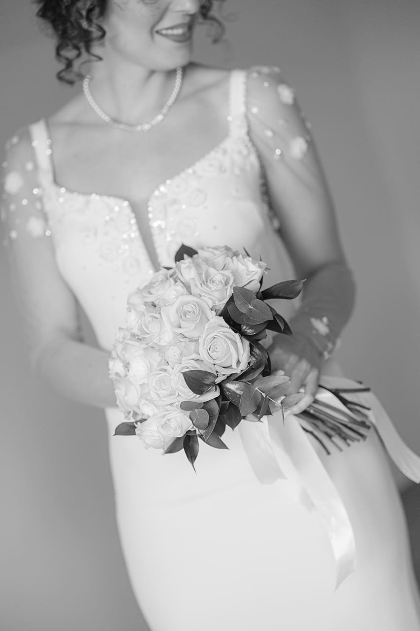 Dettagli dell’abito e del bouquet della sposa durante un matrimonio a Cosenza