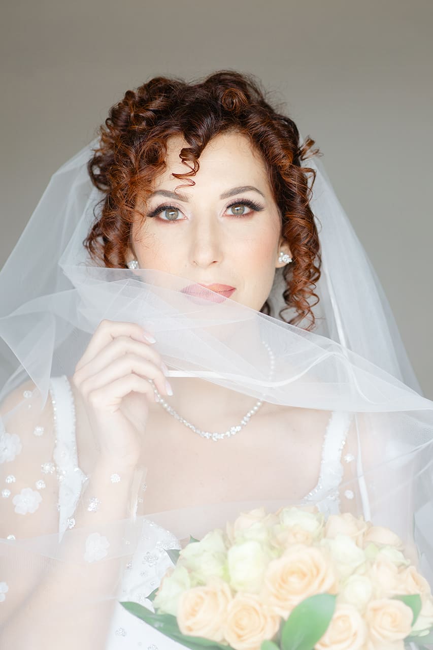 Ritratto della sposa in abito e velo al termine della preparazione a casa in provincia di Cosenza